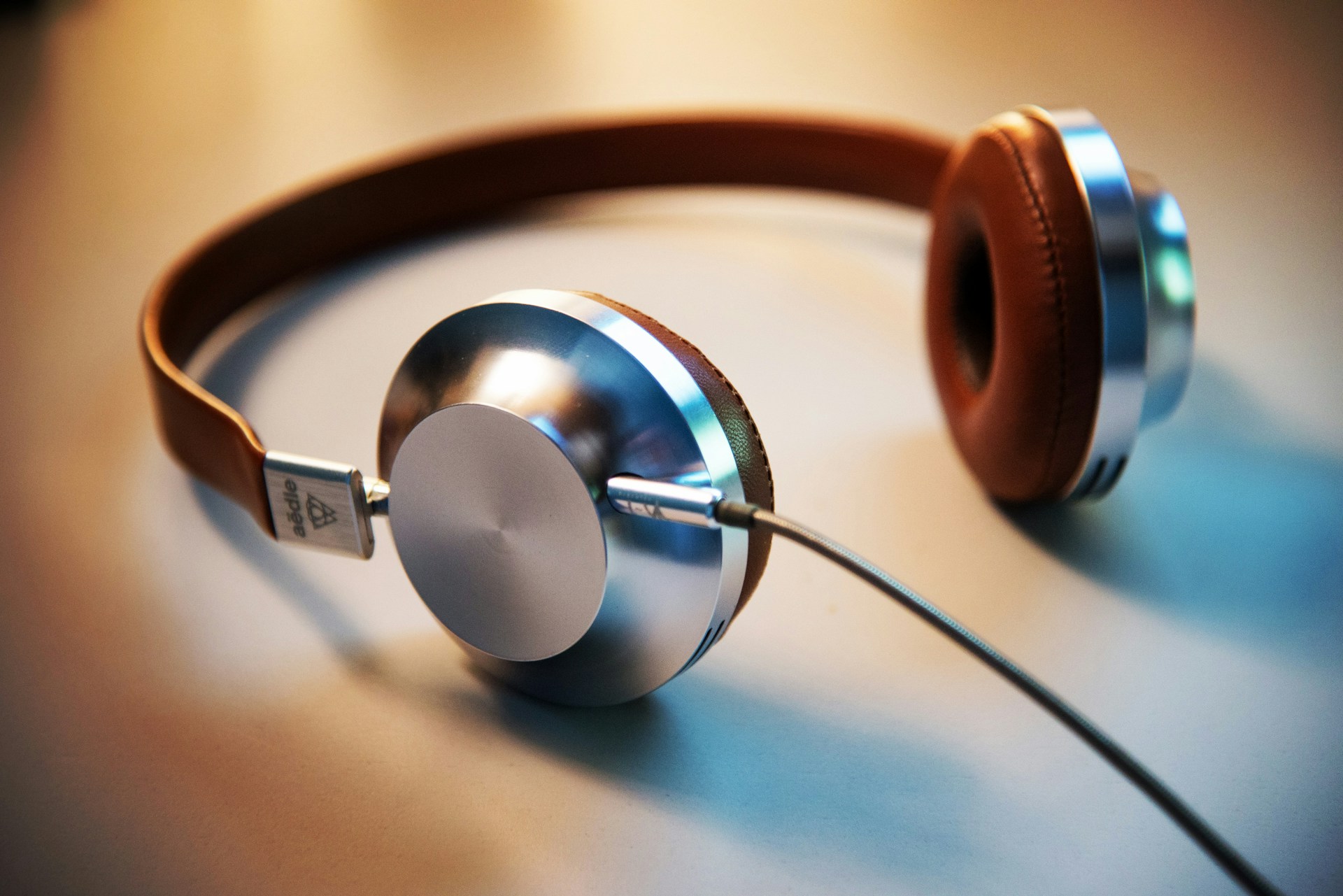 Closed-back headphones resting on a desk beside a notebook
